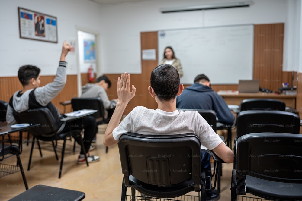 uma sala de aula cheia de alunos levantando as mãos no ar