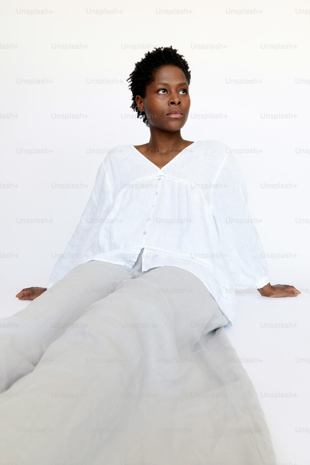 a woman sitting on the ground with her legs crossed
