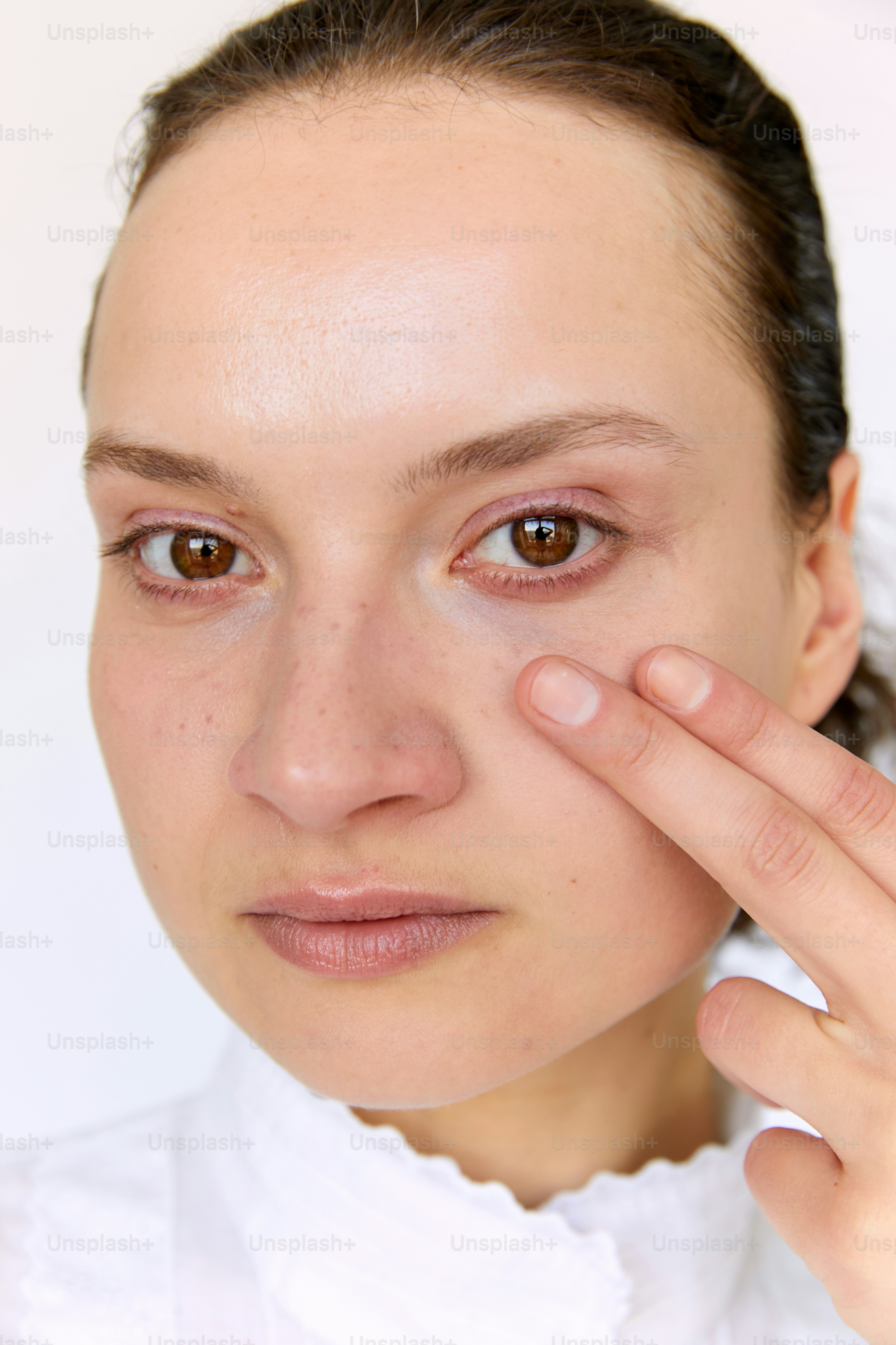 a woman holding her eye up to her face