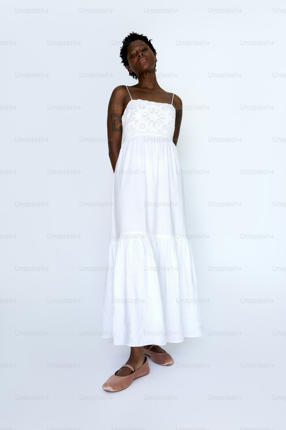 Una mujer de pie con un vestido blanco