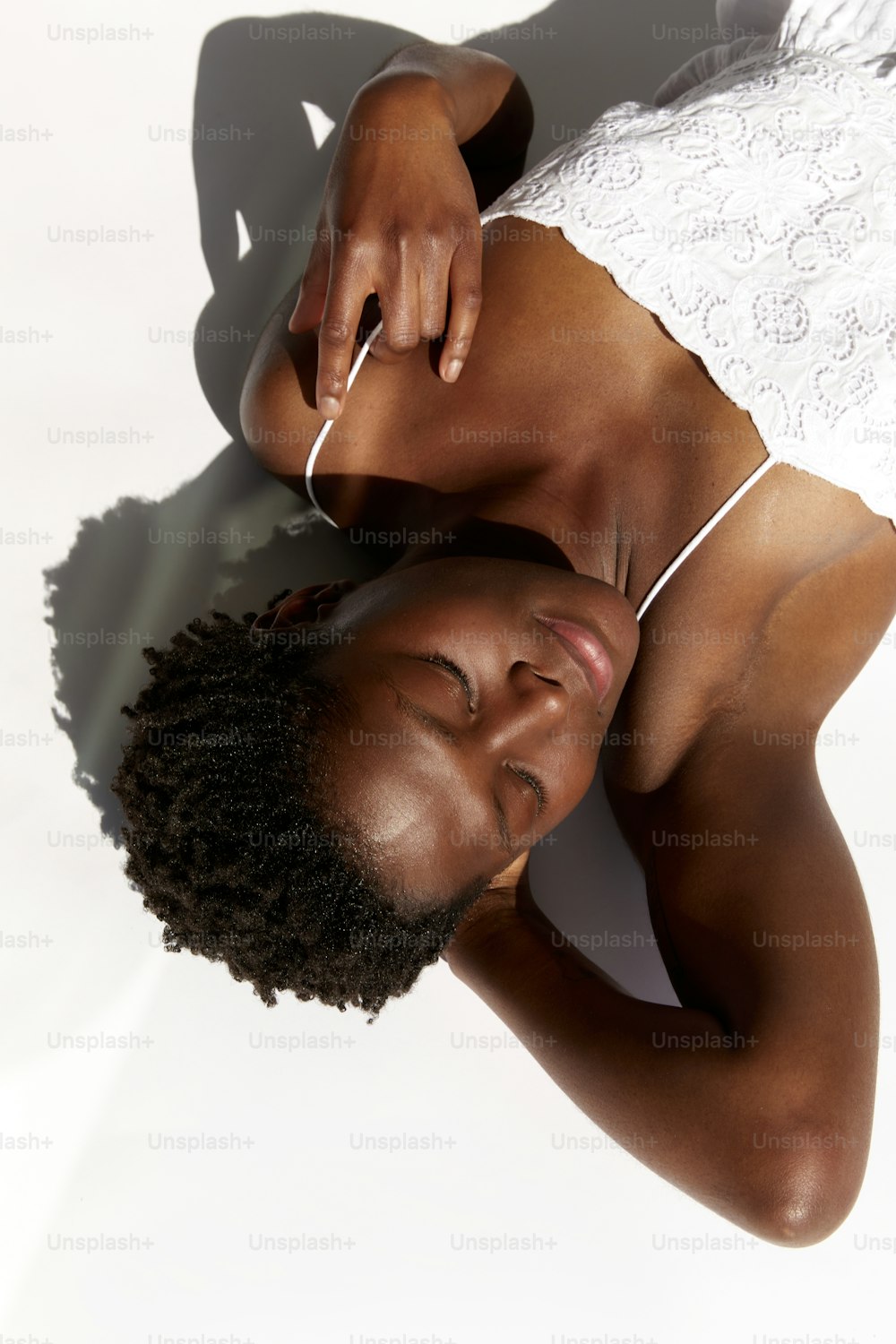 a woman in a white top is laying down