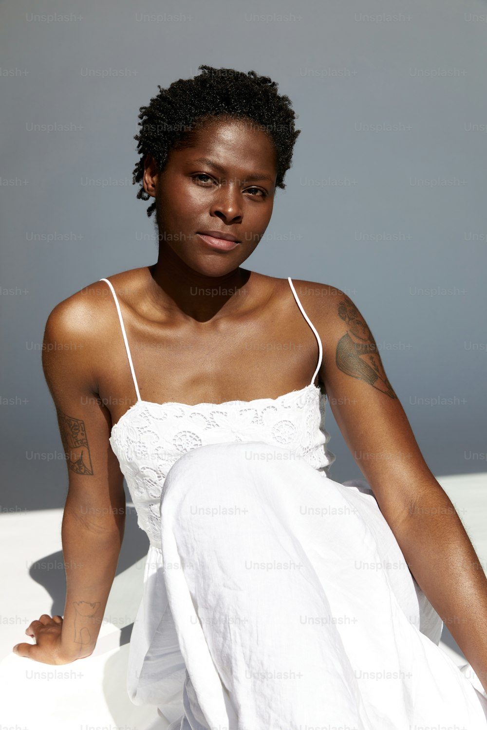 a woman in a white dress sitting down