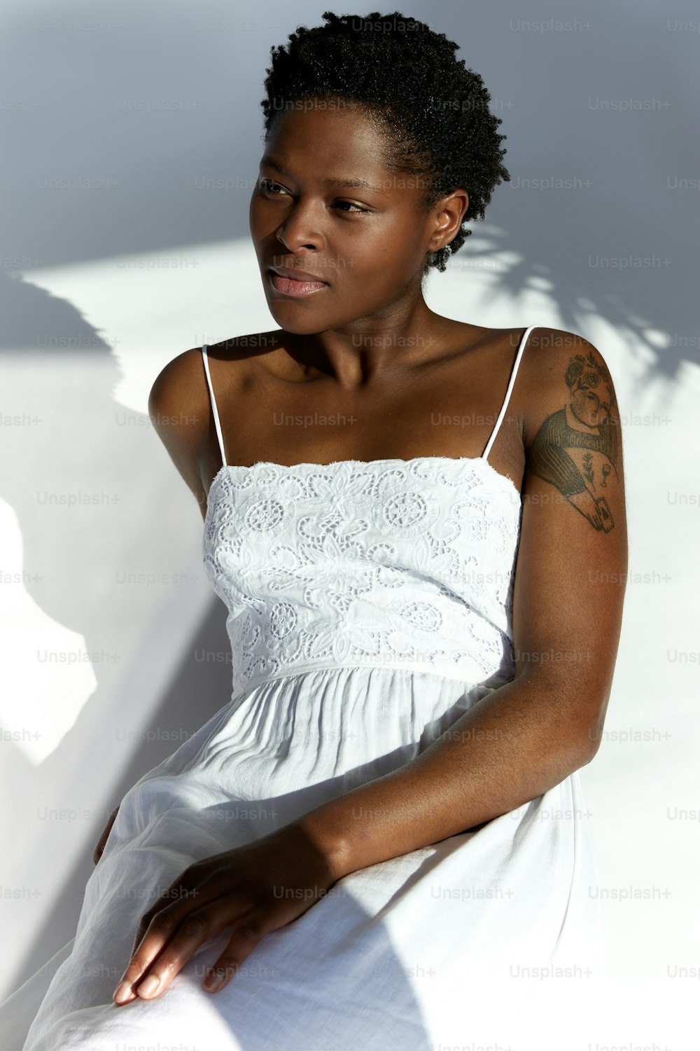 Eine Frau in einem weißen Kleid setzt sich