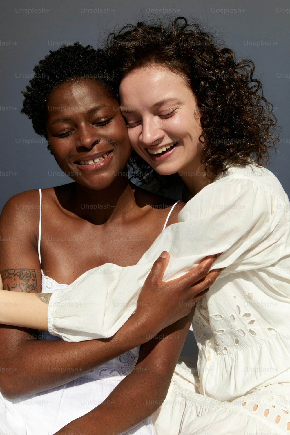 a couple of women hugging each other on a bed