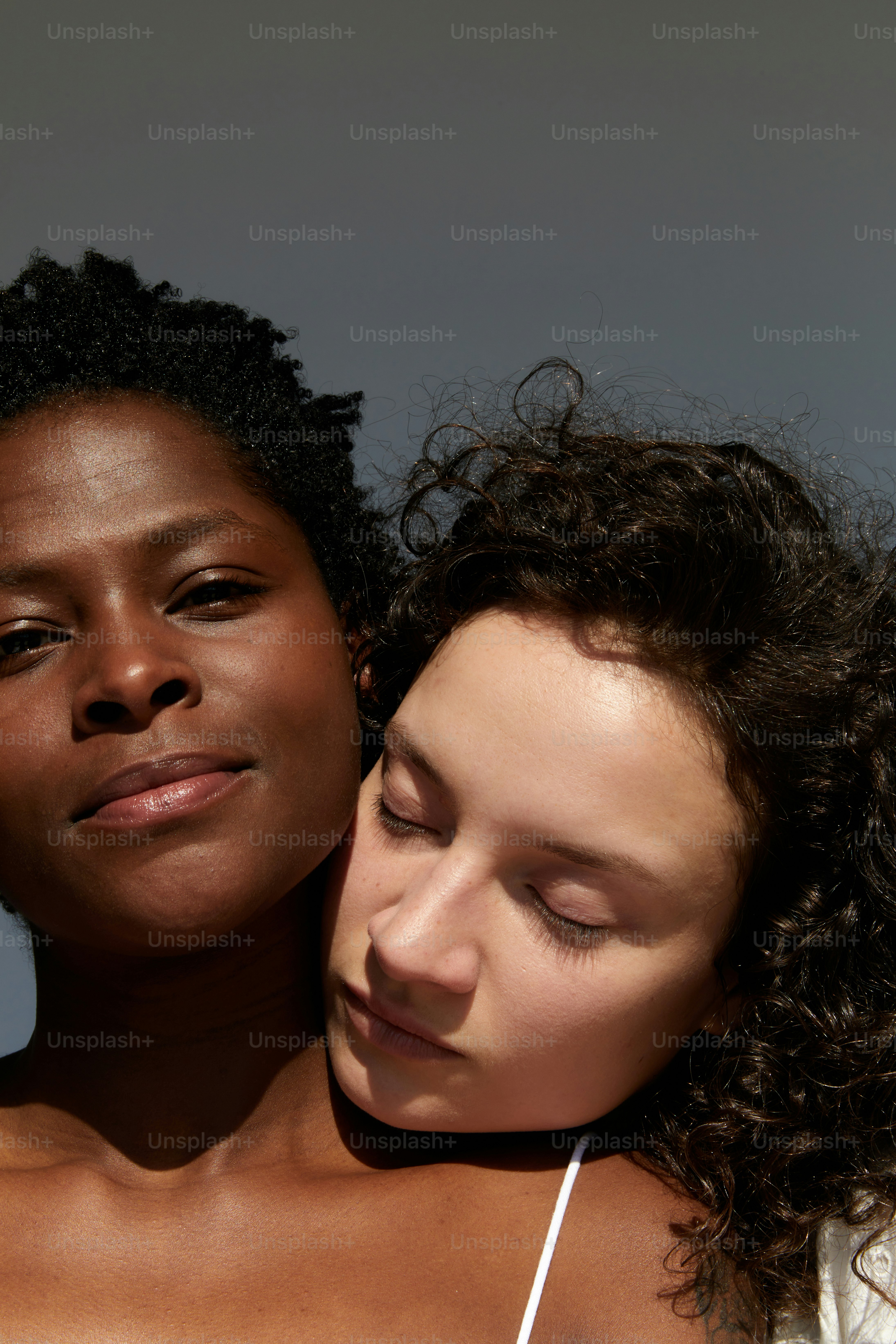 a woman holding a cell phone next to another woman