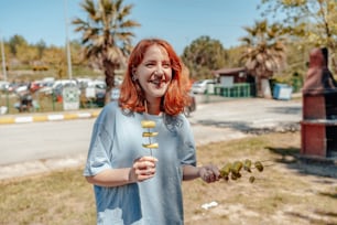 a woman with red hair holding a bunch of olives