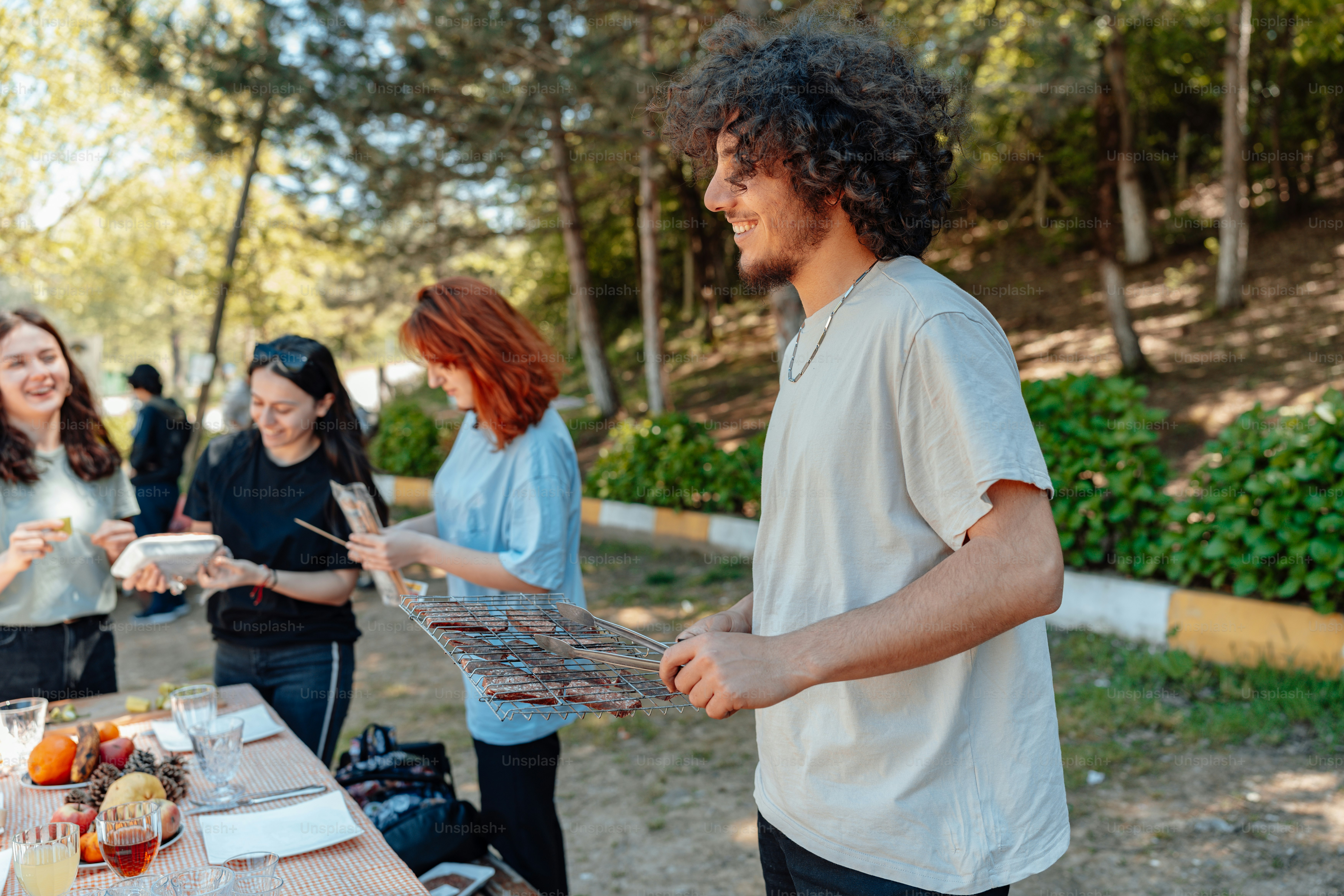 A group of people standing around a table with food on it photo – Food ...