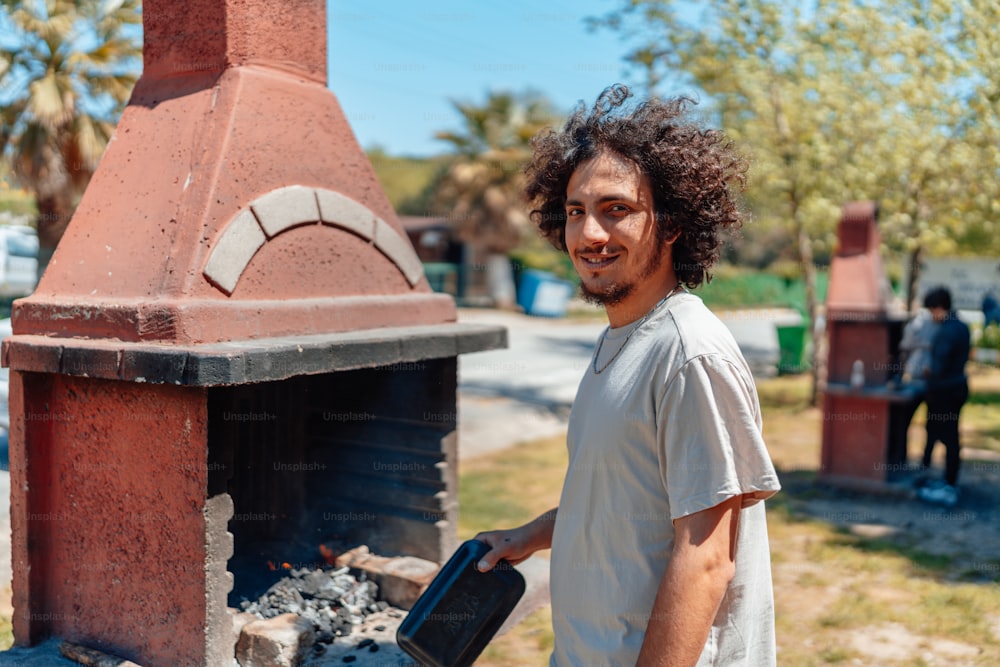 a man standing in front of a brick oven