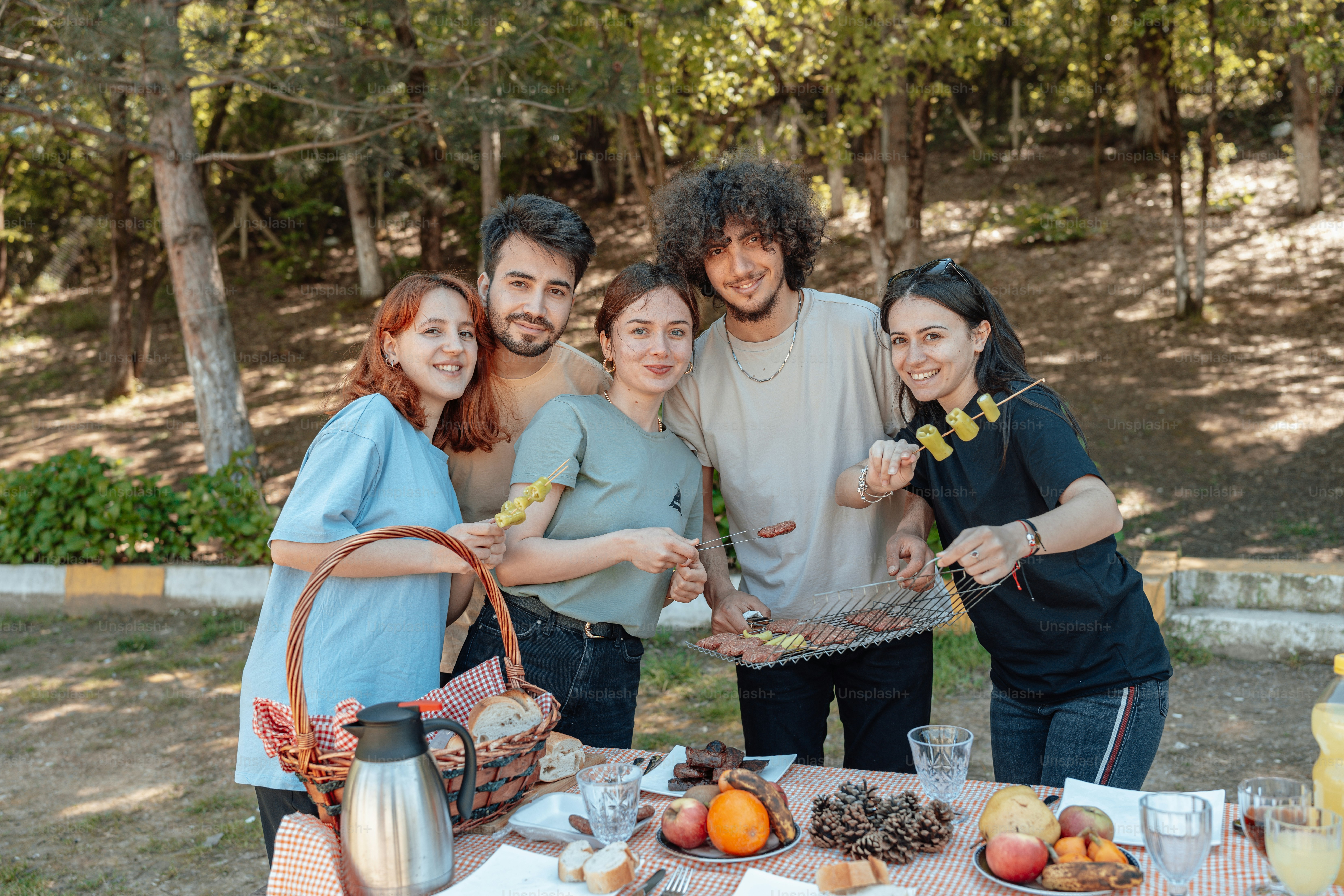 A group of people standing around a table with food photo – Bbq party ...