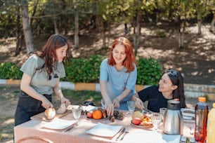 a group of women standing around a table with food on it