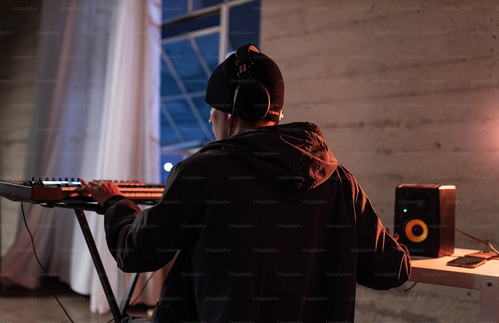 a man in a black hoodie is playing a musical instrument