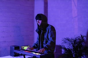 a man in a hooded jacket playing a keyboard