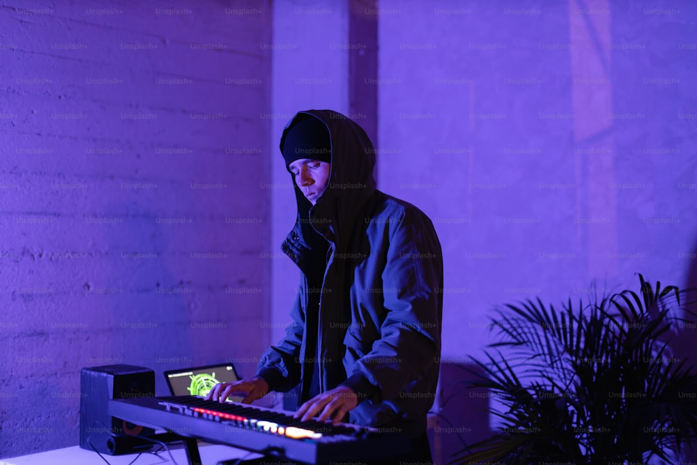 um homem com uma jaqueta com capuz tocando um teclado