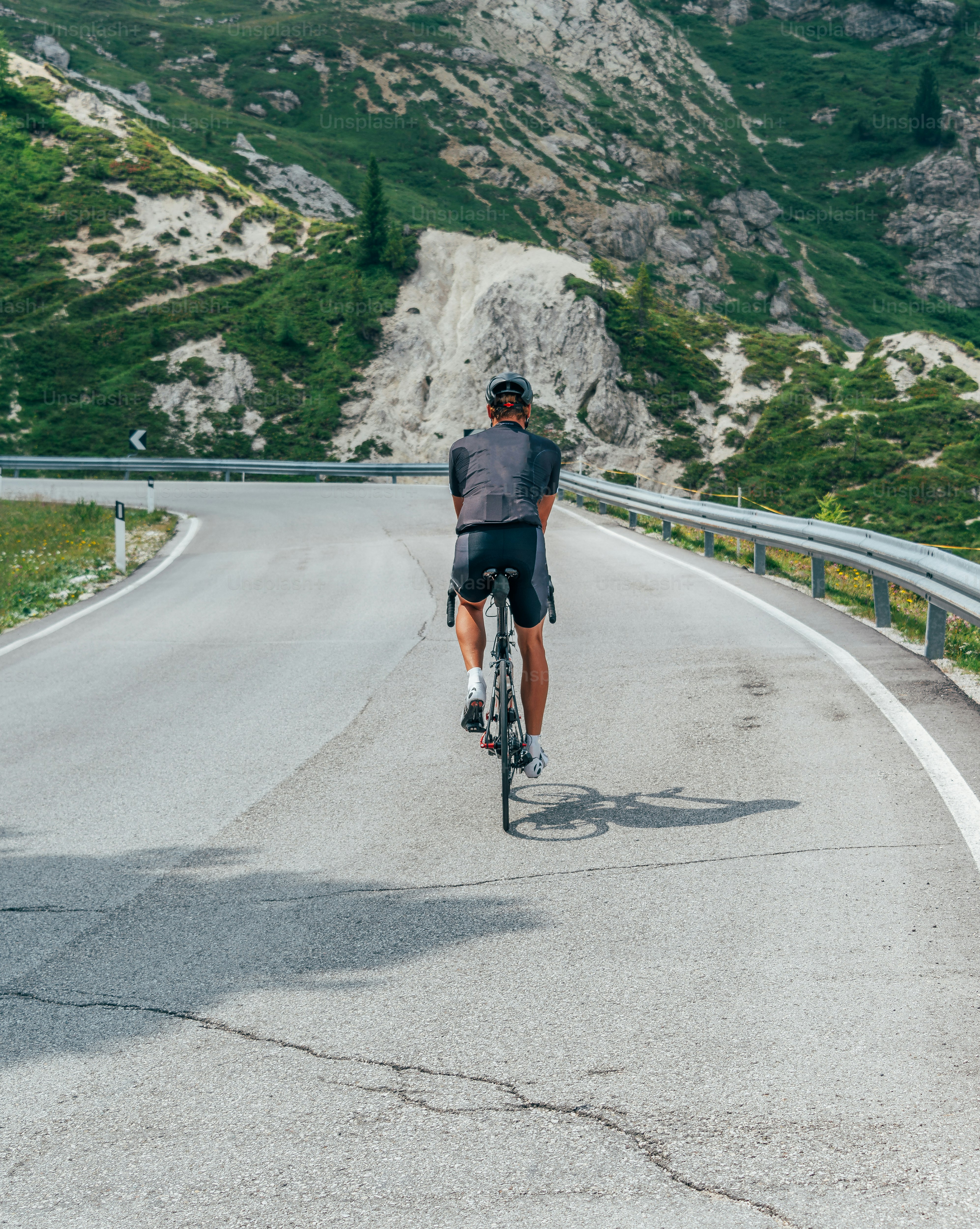 Un uomo che va in bicicletta lungo una strada tortuosa