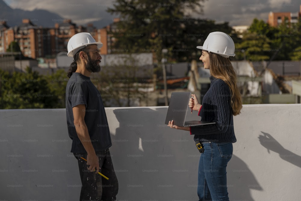 a man and a woman wearing hard hats talking to each other