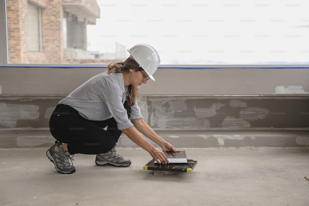 a woman in a hard hat is working on a skateboard