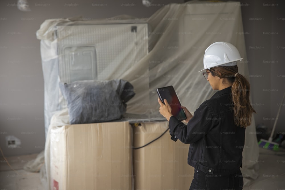 a woman wearing a hard hat and holding a tablet