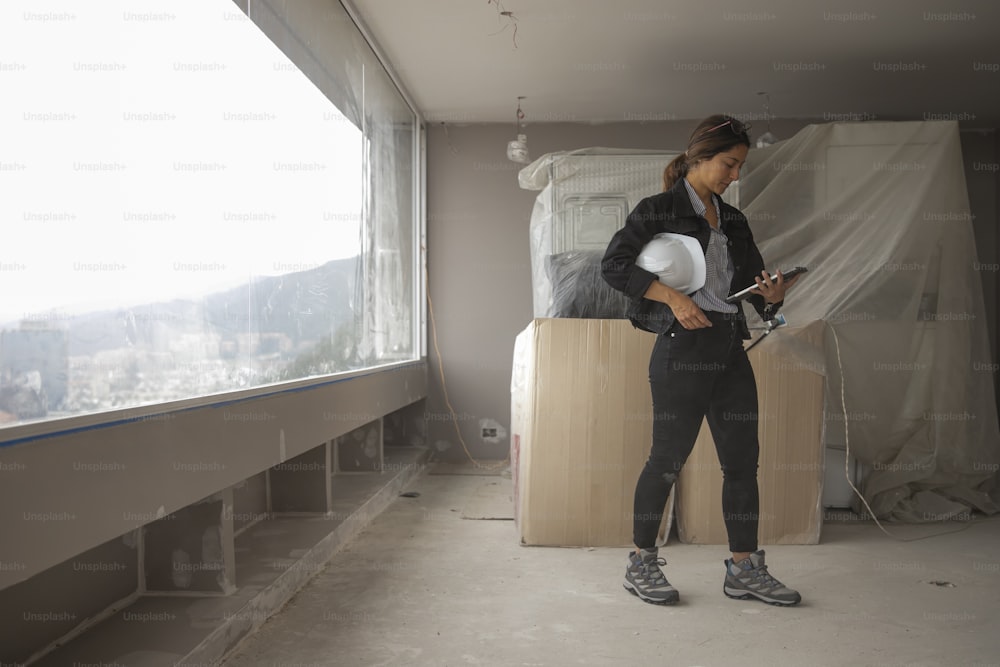 a woman standing in a room holding a cell phone