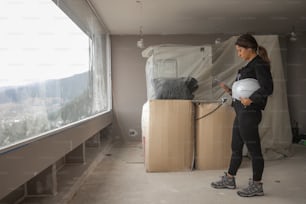 a woman standing next to a window holding a baby in her arms