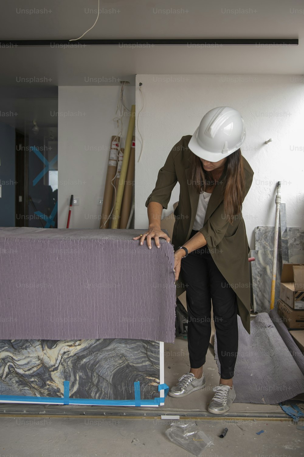 a woman in a hard hat working on a piece of furniture