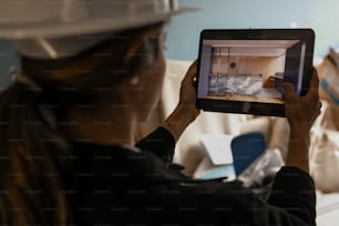 a woman in a hard hat holding a tablet