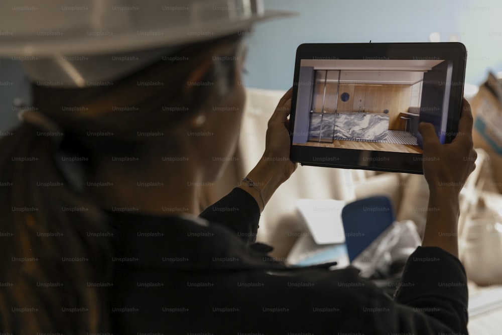 a woman in a hard hat holding a tablet
