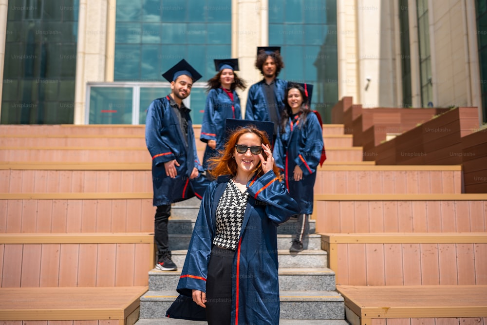 Une femme en robe de graduation debout sur les marches