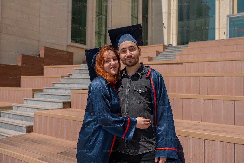 a man and woman in graduation gowns hugging each other