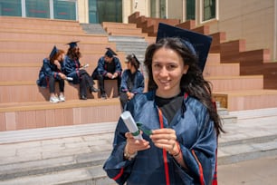 a woman in a graduation gown holding a cell phone