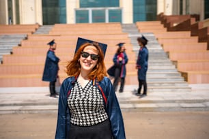 une femme portant une casquette et une robe de fin d’études