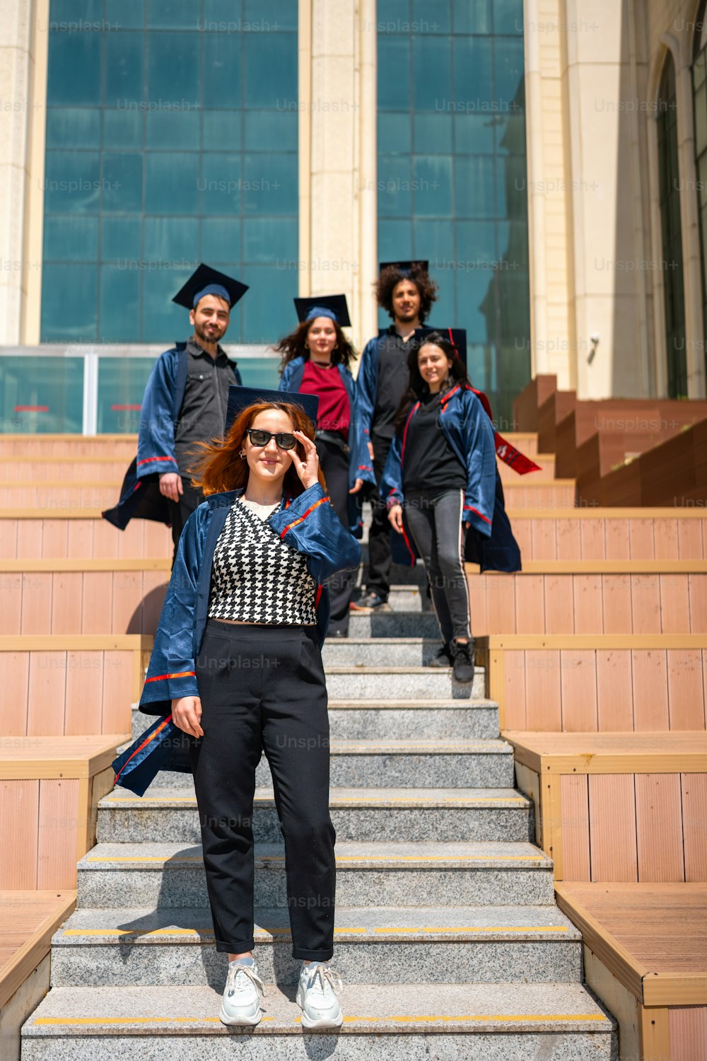 a group of graduates walking down a flight of stairs