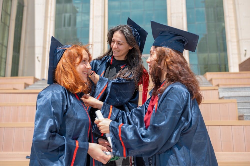卒業式のガウンを着て隣り合って立っている女性のグループ