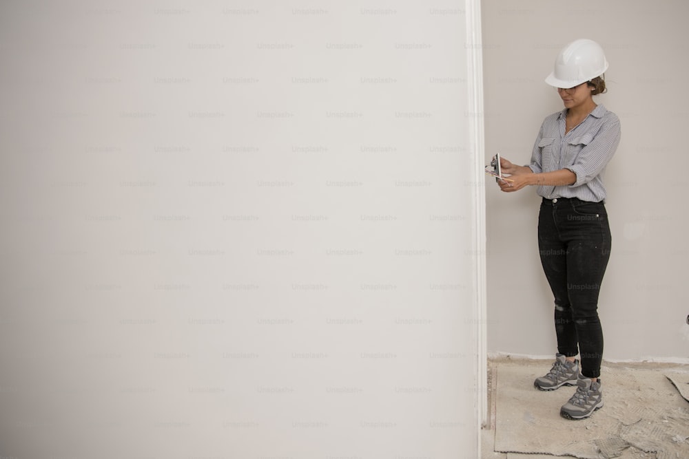 a woman wearing a hard hat and holding a pair of scissors