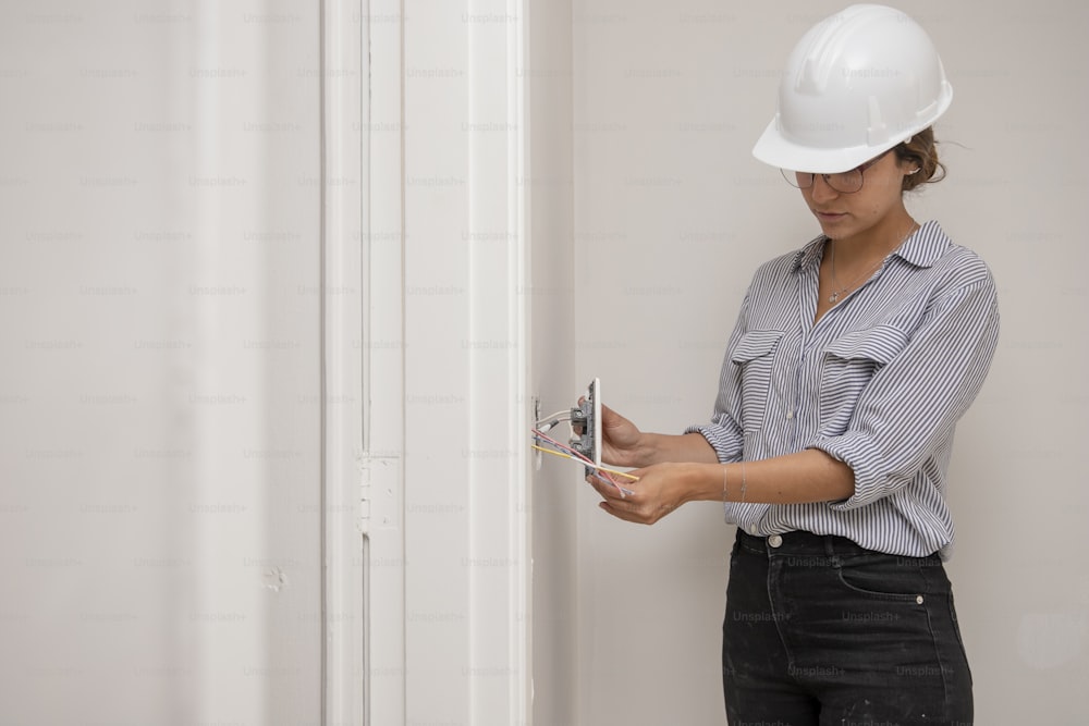 a woman in a hard hat is opening a door