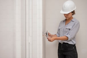 a woman in a hard hat is opening a door