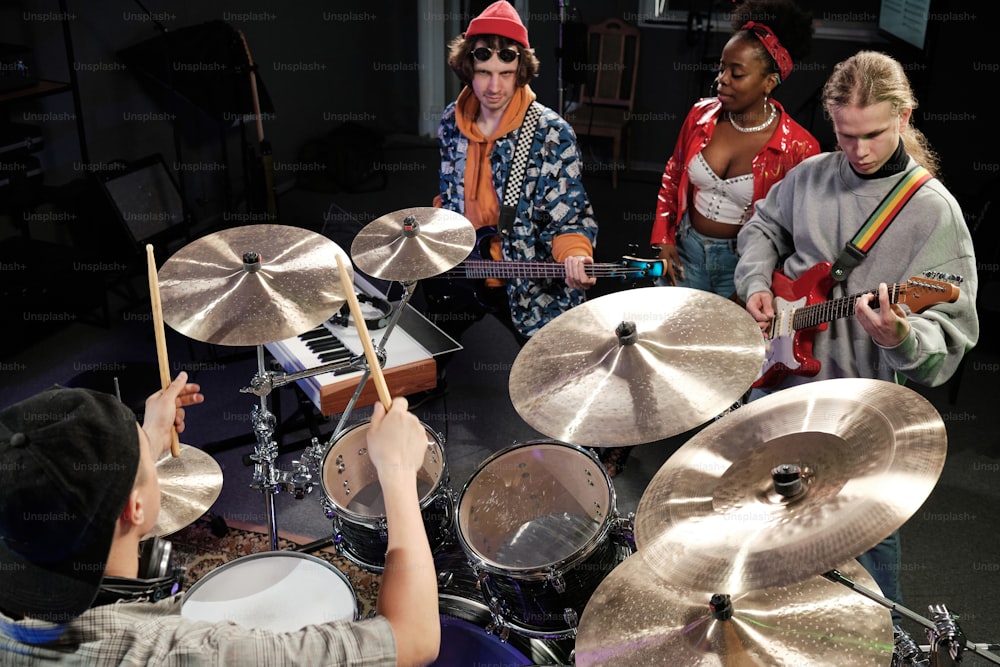a group of people standing around a drum set