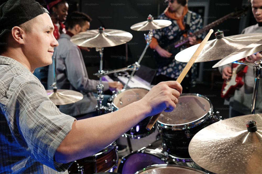 a man playing drums in front of a group of people