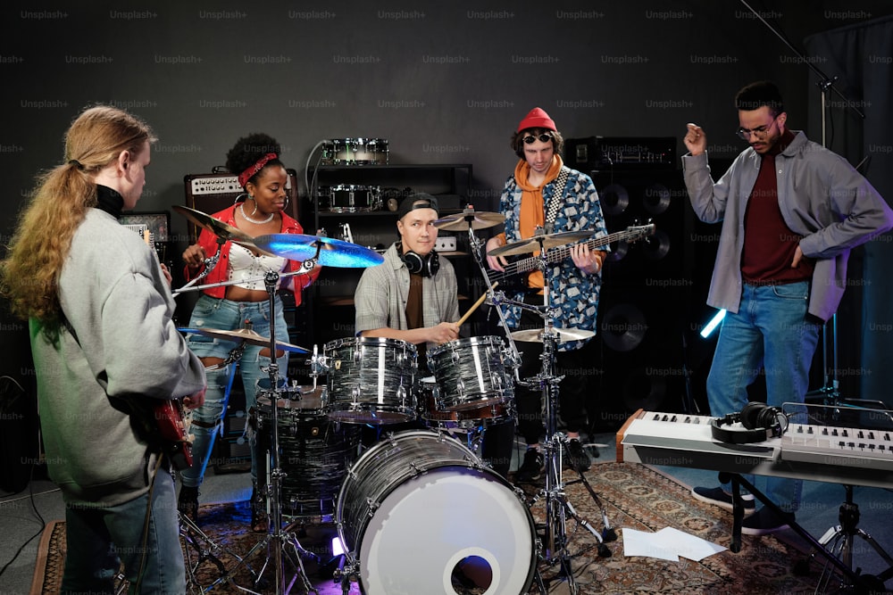 a group of people standing around a drum set