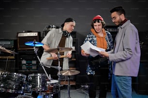 a group of people standing around a drum set