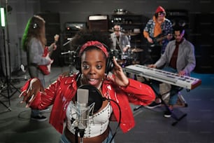 a woman with headphones on singing into a microphone
