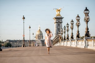 パリの朝の景色の間に歩く美しい女性と有名なアレクサンドル橋の眺め
