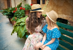 souriant voyageurs modernes mère et enfant à Pienza, Italie assis sur un banc