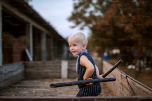 Cute cheerful small boy playing in a wooden trailer with metal pipes.