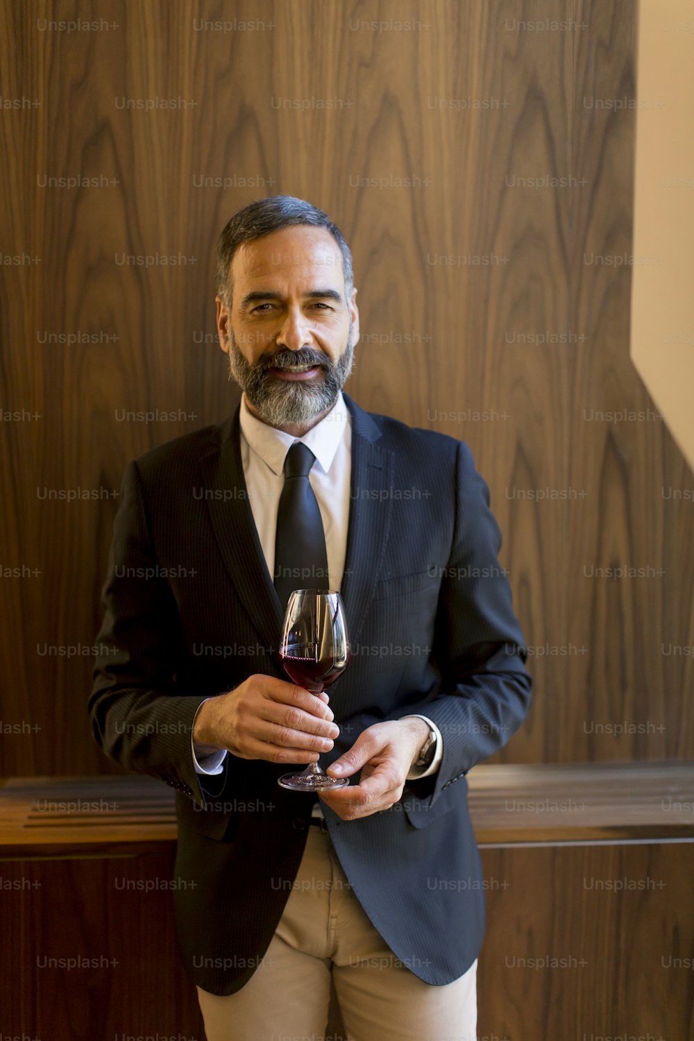 Ritratto di bell'uomo con il bicchiere di vino rosso