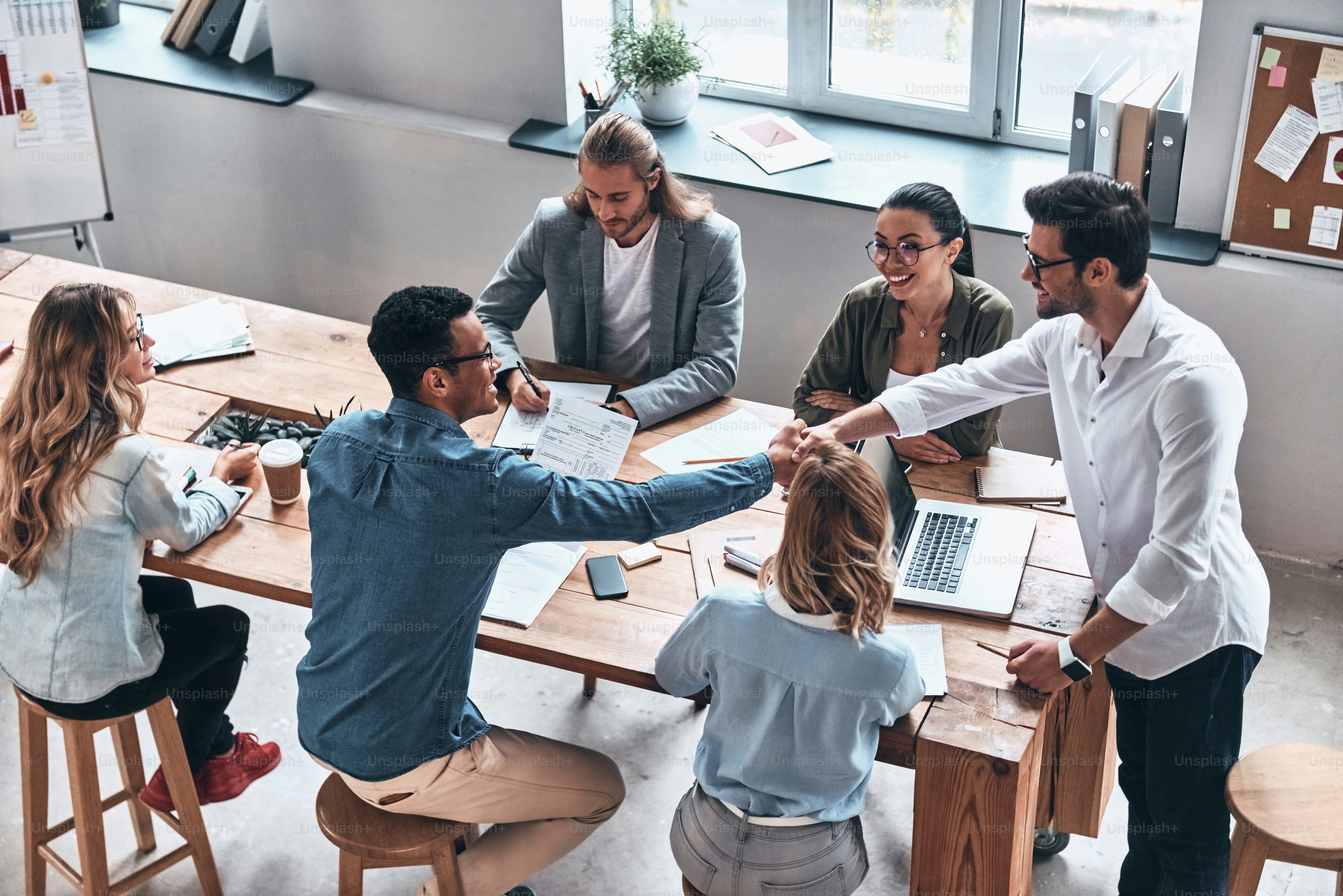 Top view of modern young men shaking hands while working in the office