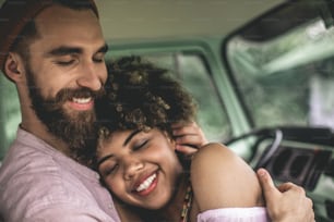 Love is in air. Close up portrait of happy afro-american young woman closing eyes while putting her head on chest of hipster beloved man