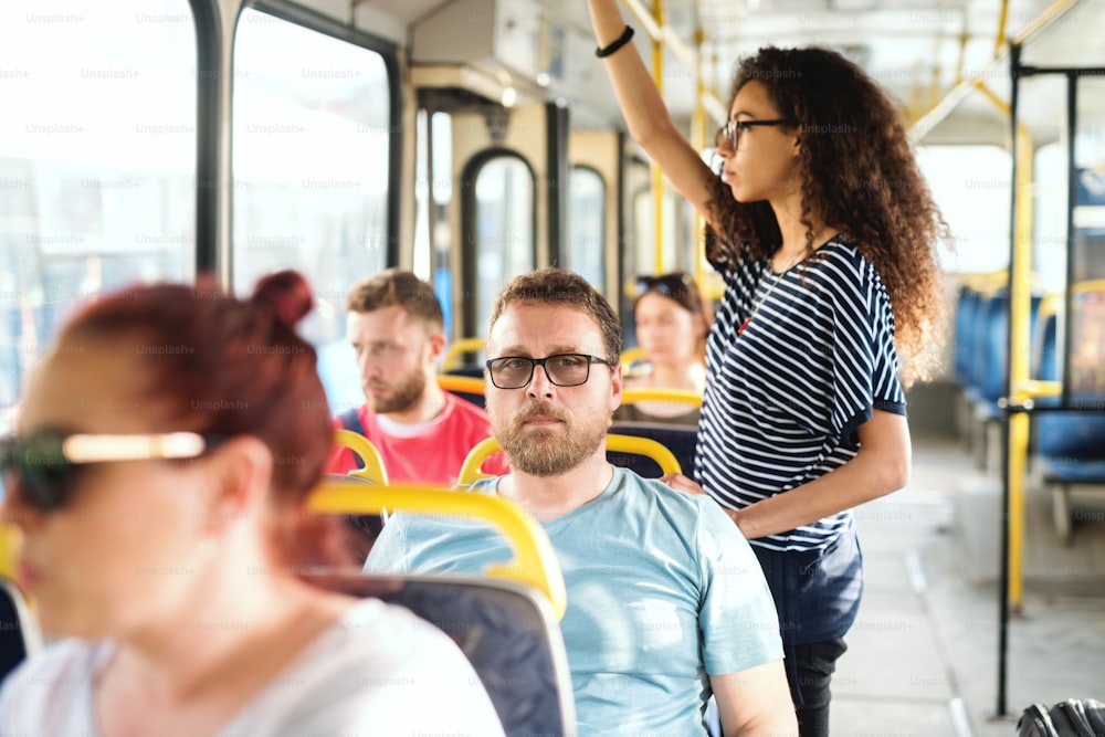 Grupo multicultural de personas que viajan en el autobús urbano.