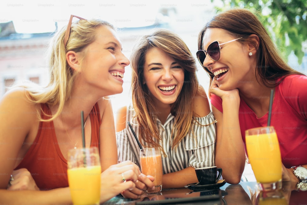 Three beautiful friends in a cafe having fun