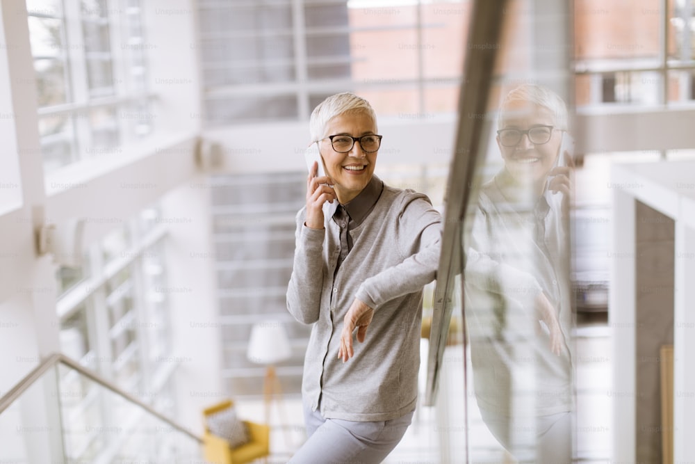 Portrait of senior businesswoman using mobile phone in modern ofice