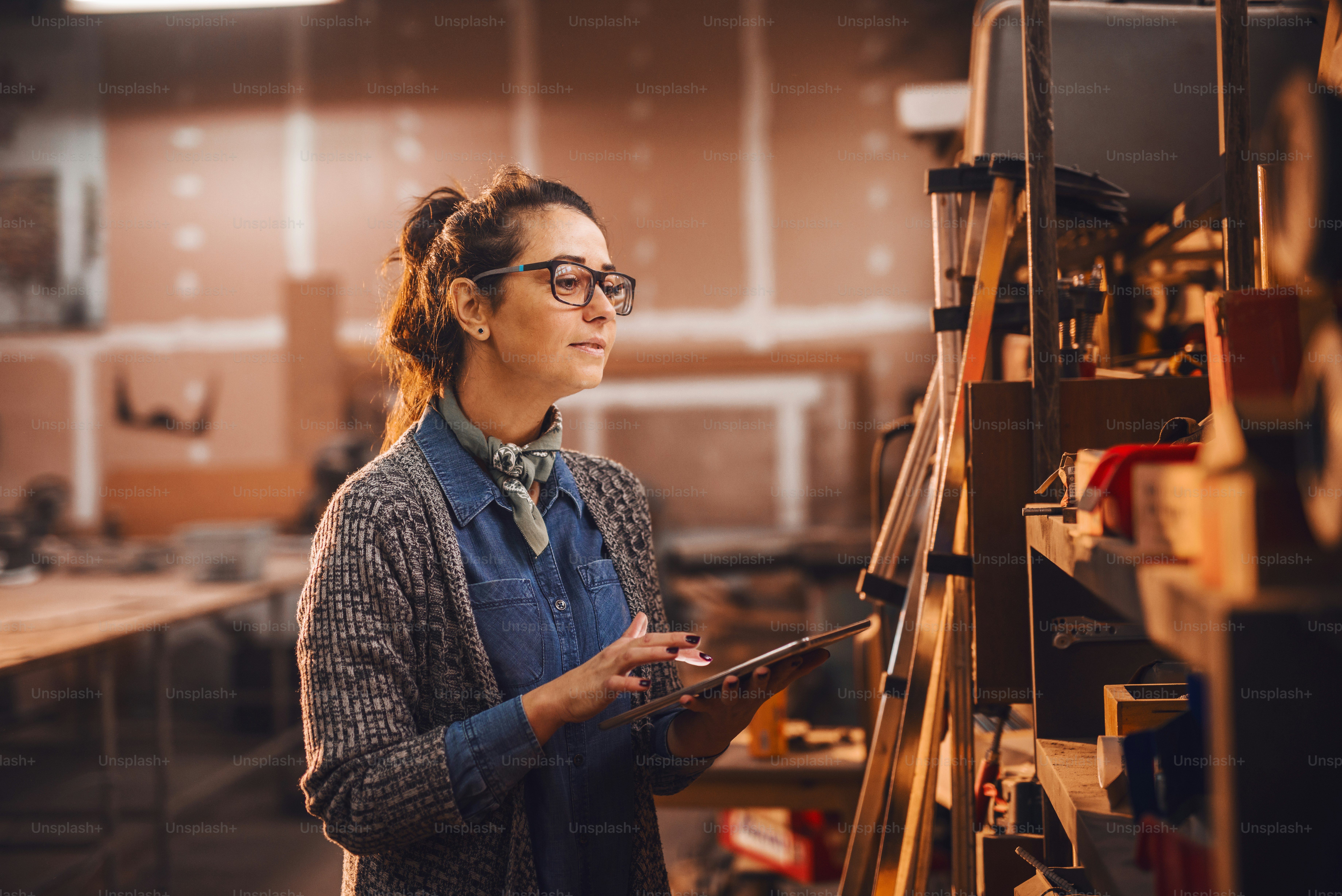 Mulher carpinteiro usando tablet enquanto em pé na oficina.